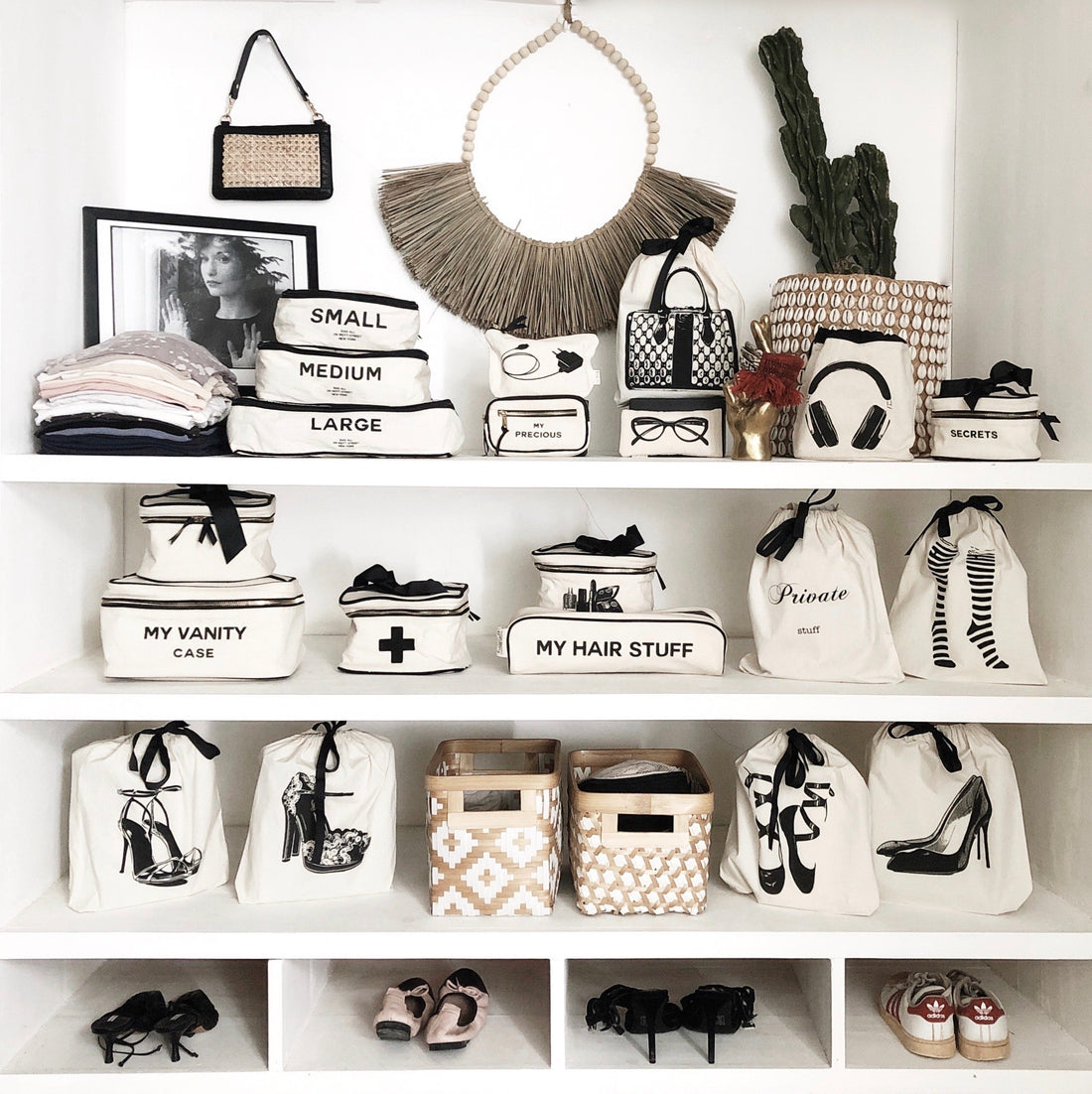 Shelf in a home organized with decor, camera case, earbuds case, books and tech cases. 