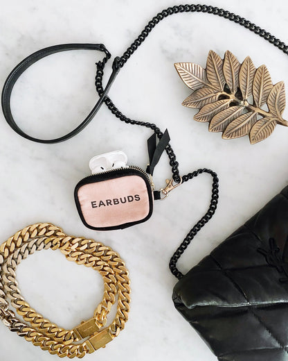 Bag-all Handbag Organizer Trio featuring pink earbud case with black chain strap, displayed alongside gold leaf decor and chain accessories on marble surface