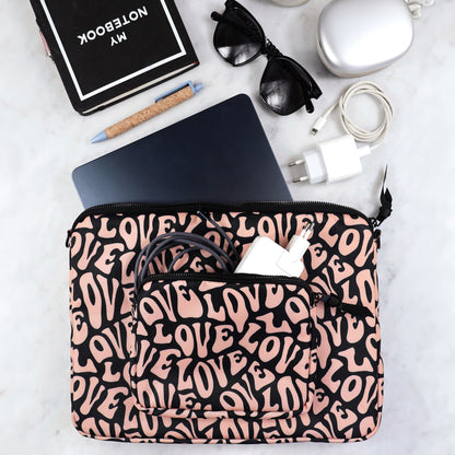 Bag-all padded laptop case with love pattern design, featuring charger pocket and secure elastic band, shown with sunglasses, notebook and charging accessories on marble surface