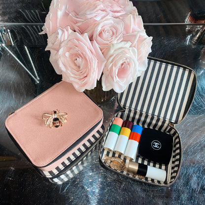 Bag-all Cosmetics/Trinket Box in black and pink with striped lining, gold bee embellishment, and convenient storage for makeup essentials, shown with pink roses