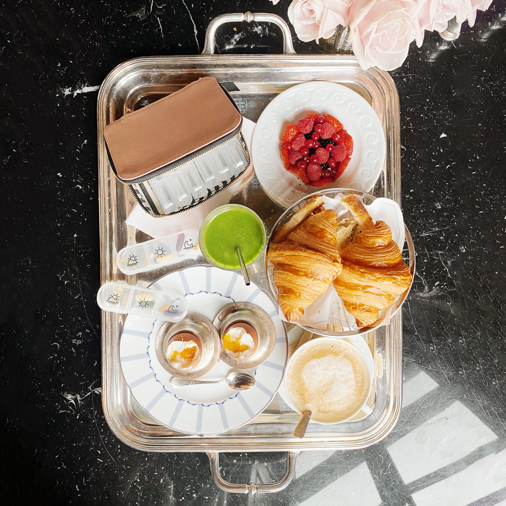 The image shared appears to be unrelated to the pill travel case product. It shows a breakfast or brunch setting with croissants, beverages, and pastries on a silver tray. 

For the pill travel case product, here's an appropriate ALT text following your requirements:

Bag-all Large Pill Travel Case in pink blush cotton featuring individual daily pill organizer compartments and secure zipper closure for organized medication storage