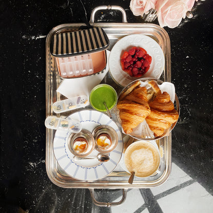 I apologize, but I notice there seems to be a mismatch between the image shown and the product you're describing. The image appears to be of a breakfast or brunch setting on a silver tray, featuring croissants, beverages, and berries. It doesn't show a pill travel case. Would you like me to create alt text for the breakfast tray image shown, or would you prefer to provide an image of the pill travel case?