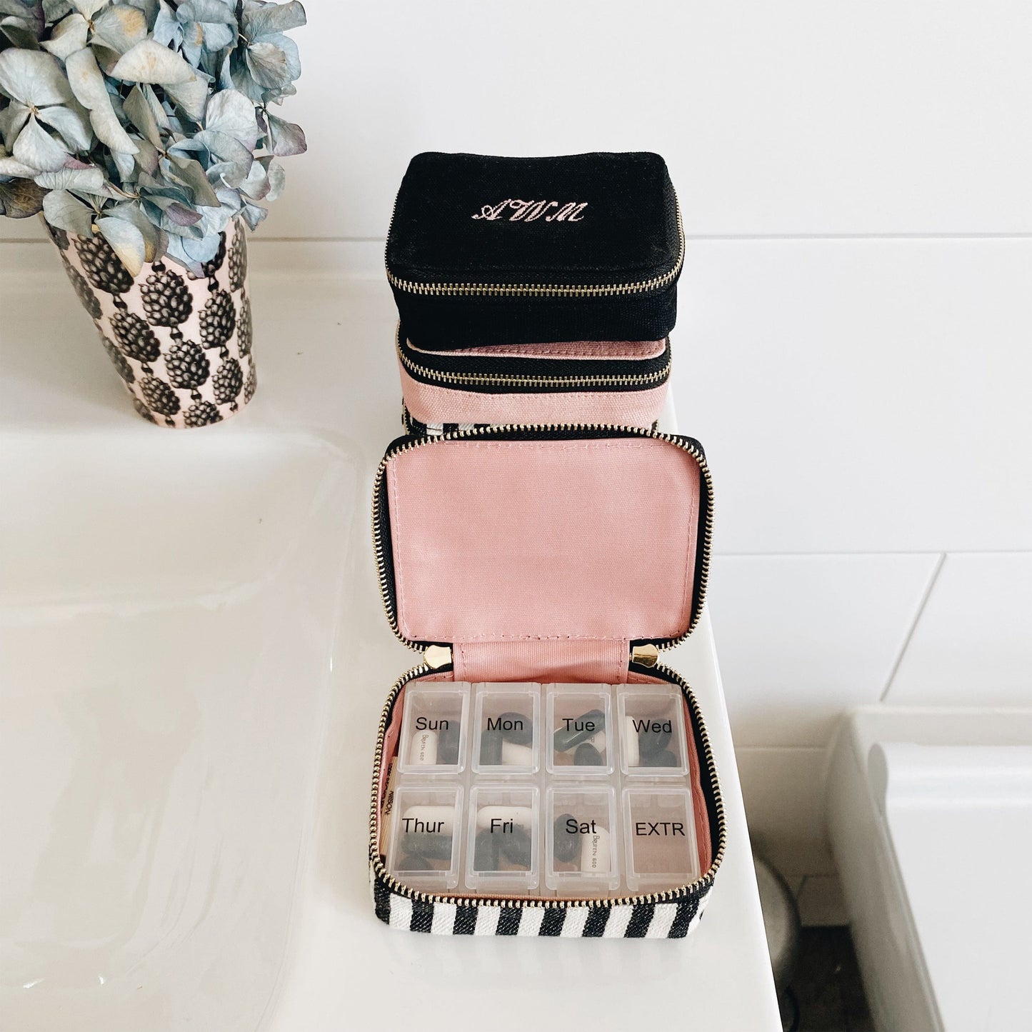 Bag-all Pill Organizing Case with Weekly Pill Organizer features a black cotton exterior, pink interior, striped pattern, and convenient compartments for daily medication storage - stylish and practical medication management solution