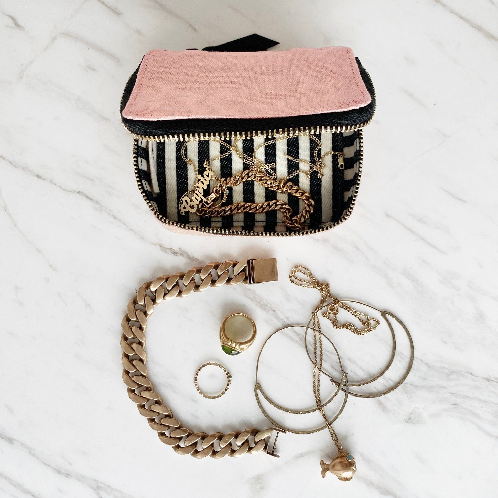 Bag-all Handbag Organizer Trio in pink/blush featuring striped interior, displayed with gold jewelry including chain bracelet, rings, and necklace on marble surface