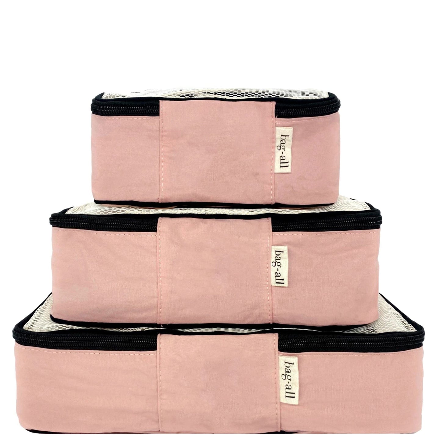 Bag-all Weekend Essential Packing Set 4-Pack in pink/blush cotton, featuring three stacked organizer cubes with black zippers and brand labels, perfect for travel organization