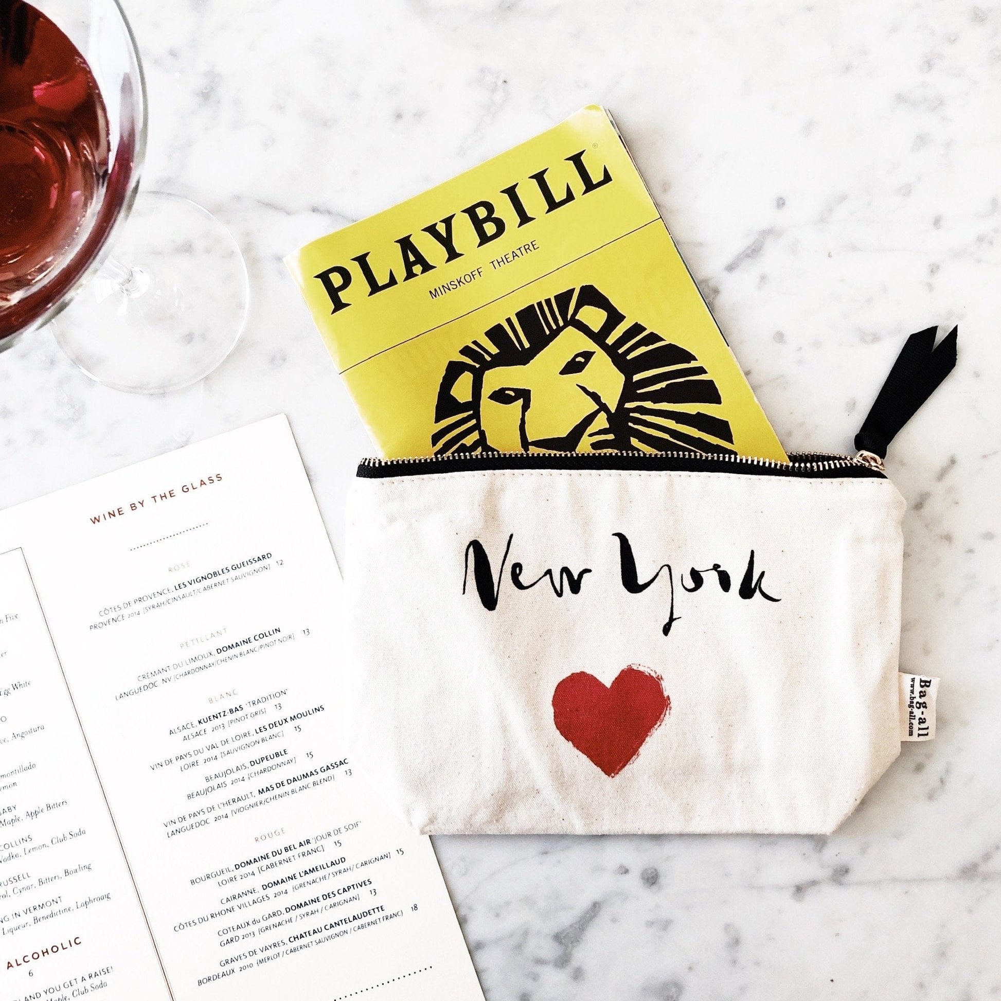 New York heart case holding a playbill. 