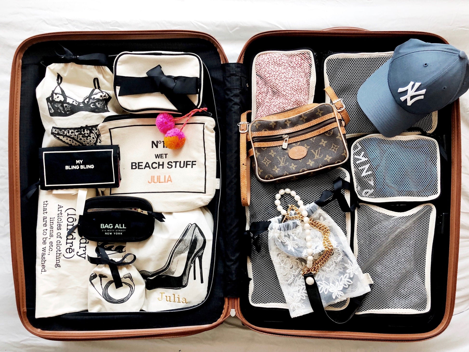 Suitcase filled with packing cubes, louis vuitton bag, shoe bag, beach bag and more. 