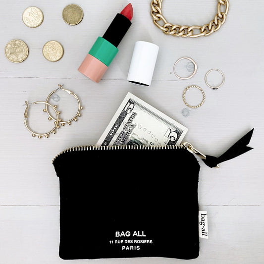 Bag-all Mini Trinket Pouch in Black with everyday essentials including lipstick, coins, jewelry, and cash displayed on white surface, showcasing compact storage solution