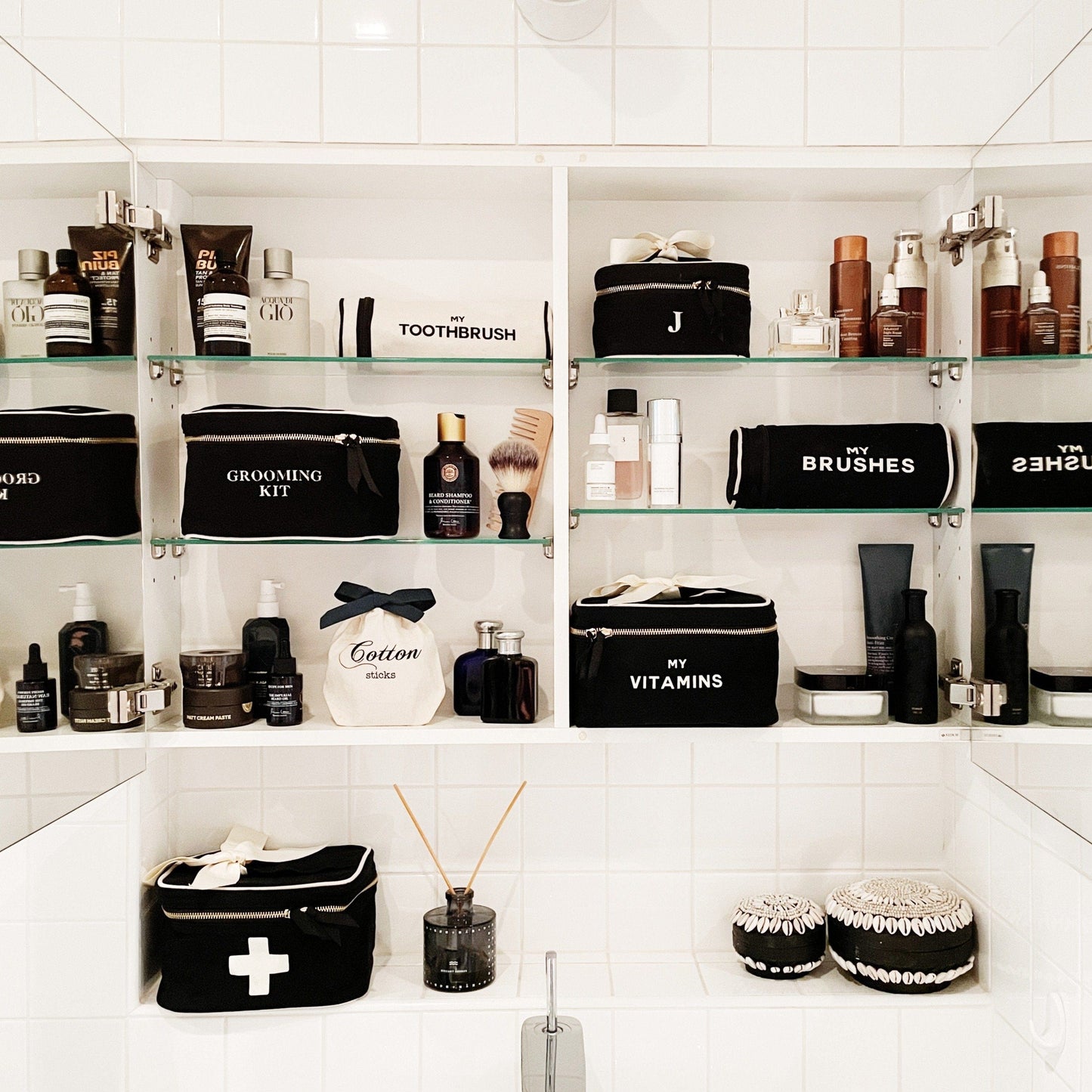 Bathroom mirror with all bathroom necessities and a grooming kit box in the shelves. 